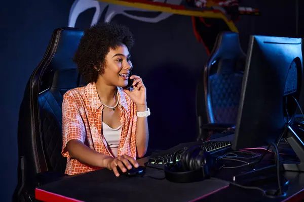 A relaxed GUMBALL player smiling at her station in the bright family hall